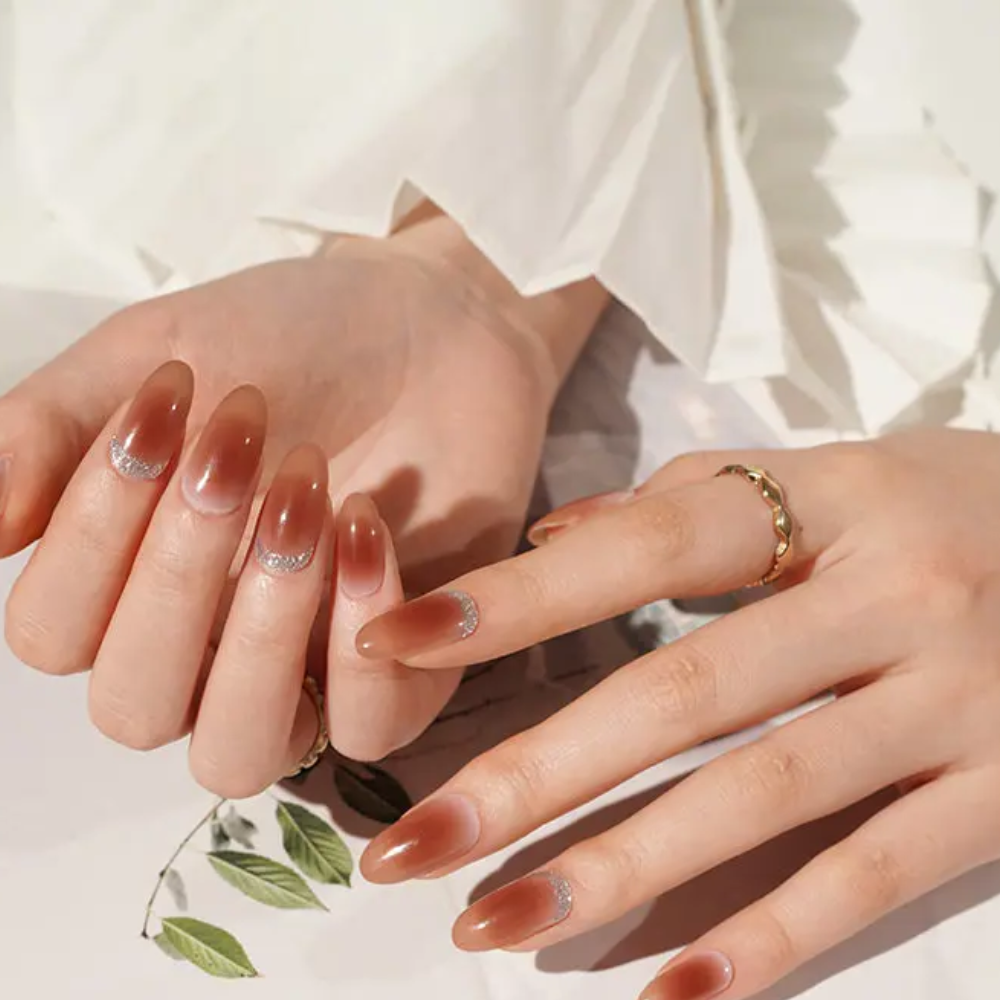 Ongle en gel KRISTEN caramel ombré avec accents pailletés : manucure portée avec une tenue claire