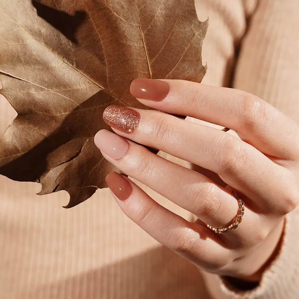 Ongle en gel MARISSA brun, nude rosé et paillettes cuivrées : main en décor automnal