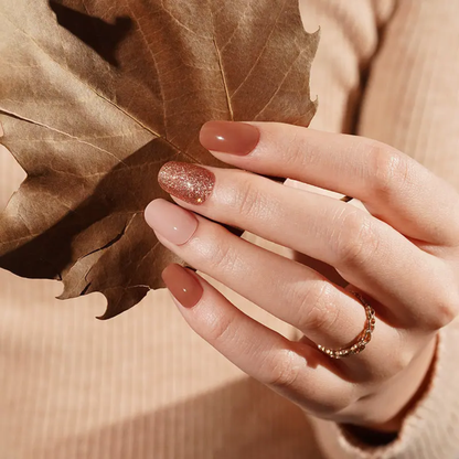 Ongle en gel MARISSA brun, nude rosé et paillettes cuivrées : main en décor automnal